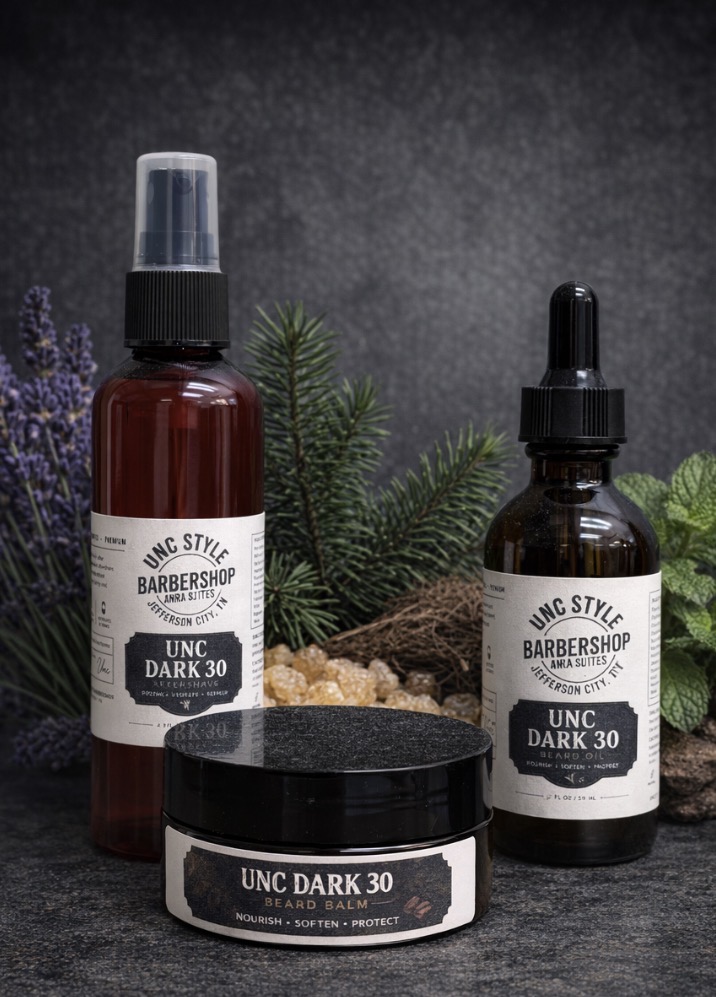 Unc Dark 30 aftershave spray, beard oil dropper bottle, and beard balm jar with lavender, fir branches, frankincense, and mint